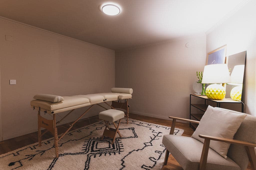 Treatment Room — wide view with massage table and armchair