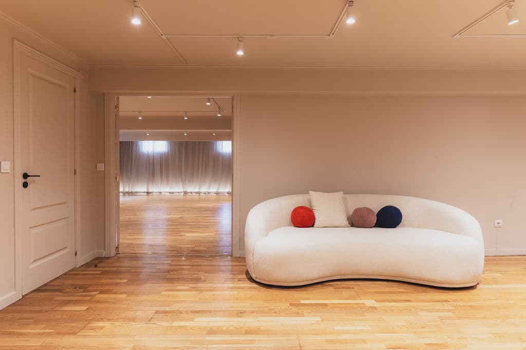 The Workshop — curved sofa with studio beyond