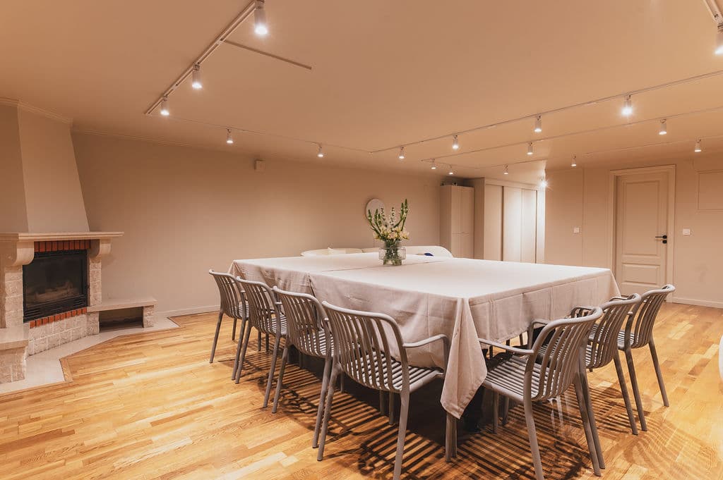 The Workshop — dining table with fireplace close-up
